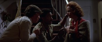 Movie still from “Poltergeist” (1982), directed by Tobe Hooper – A group of men sitting around talking to each other; Medium shot, Over the shoulder angle
