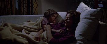 Movie still from “Poltergeist” (1982), directed by Tobe Hooper – A woman and a child laying on a couch; Medium shot, High angle