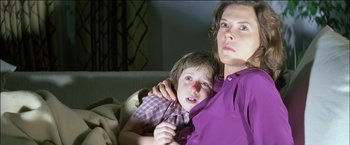Movie still from “Poltergeist” (1982), directed by Tobe Hooper – A woman holding a child in her arms on a couch; Close Up shot, Low angle
