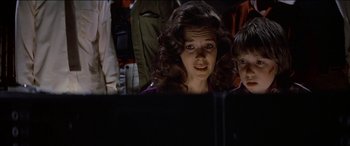Movie still from “Poltergeist” (1982), directed by Tobe Hooper – A woman and a child looking at a computer screen; Medium shot, Over the shoulder angle