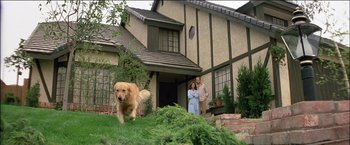 Movie still from “Poltergeist” (1982), directed by Tobe Hooper – A man and a woman standing in front of a house with a dog; Wide shot, Low angle