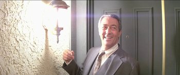 Movie still from “Poltergeist” (1982), directed by Tobe Hooper – A man in a suit and tie holding a light; Close Up shot, Low angle
