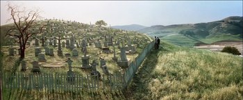 Movie still from “Poltergeist” (1982), directed by Tobe Hooper – Two people standing on a hill near a cemetery; Extreme Wide shot, High angle