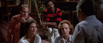 Movie still from “Poltergeist” (1982), directed by Tobe Hooper – A man and two women sitting on the ground; Medium shot, High angle