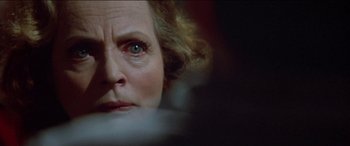 Movie still from “Poltergeist” (1982), directed by Tobe Hooper – An older woman looking at the camera with her eyes wide open; Close Up shot, Over the shoulder angle