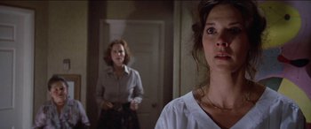 Movie still from “Poltergeist” (1982), directed by Tobe Hooper – Two women are standing in a room and one of them is looking at the camera; Close Up shot, Low angle