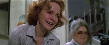 Movie still from “Poltergeist” (1982), directed by Tobe Hooper – An older woman crying with her eyes closed; Close Up shot, Over the shoulder angle