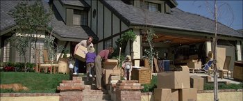 Movie still from “Poltergeist” (1982), directed by Tobe Hooper – A group of people unloading boxes from a house; Wide shot, Low angle