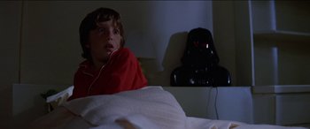 Movie still from “Poltergeist” (1982), directed by Tobe Hooper – A boy in a red shirt is laying in a bed; Close Up shot, Low angle