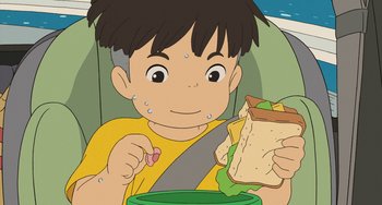 Movie still from “Ponyo” (2008), directed by Hayao Miyazaki – A boy sitting in a car seat eating a sandwich; Close Up shot, High angle