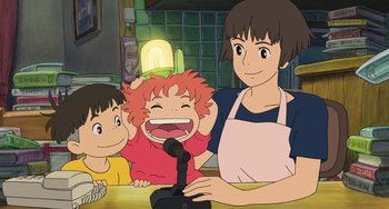 Movie still from “Ponyo” (2008), directed by Hayao Miyazaki – A woman and two children in front of a microphone; Medium shot, Low angle