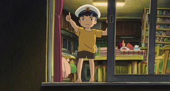 Movie still from “Ponyo” (2008), directed by Hayao Miyazaki – A boy wearing a sailor's hat is standing in front of a window; Medium shot, Low angle