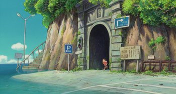 Movie still from “Ponyo” (2008), directed by Hayao Miyazaki – An animated scene of a cave with a person standing in front of it; Extreme Wide shot, High angle