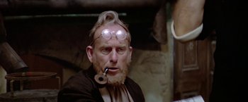 Movie still from “Popeye” (1980), directed by Robert Altman – An old man with a pipe in his mouth; Close Up shot, Low angle