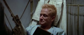 Movie still from “Popeye” (1980), directed by Robert Altman – A man with blonde hair laying in a hospital bed; Close Up shot, High angle