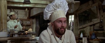 Movie still from “Popeye” (1980), directed by Robert Altman – A man wearing a chef's hat with a beard; Close Up shot, Low angle