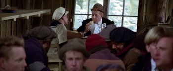 Movie still from “Popeye” (1980), directed by Robert Altman – A group of people sitting at a table eating food; Medium shot, High angle