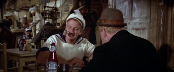 Movie still from “Popeye” (1980), directed by Robert Altman – Two men sitting at a table with a bottle of ketchup; Close Up shot, Over the shoulder angle