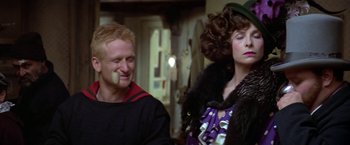 Movie still from “Popeye” (1980), directed by Robert Altman – A man and a woman are standing next to each other; Close Up shot, Over the shoulder angle