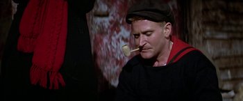 Movie still from “Popeye” (1980), directed by Robert Altman – A man with a wooden spoon in his mouth; Close Up shot, High angle
