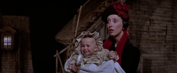 Movie still from “Popeye” (1980), directed by Robert Altman – A woman holding a baby in her arms and wearing a red hat; Close Up shot, Low angle