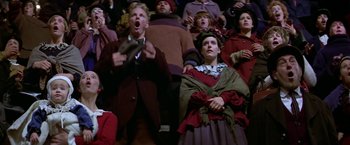 Movie still from “Popeye” (1980), directed by Robert Altman – A group of people sitting in a crowd watching a performance; Medium shot, Low angle