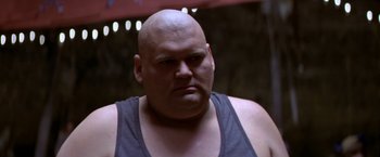 Movie still from “Popeye” (1980), directed by Robert Altman – A man with a bald head is looking at the camera; Close Up shot, Low angle