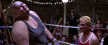 Movie still from “Popeye” (1980), directed by Robert Altman – A group of people in a boxing ring with a crowd watching; Close Up shot, Low angle
