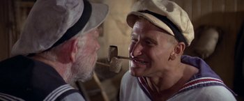 Movie still from “Popeye” (1980), directed by Robert Altman – Two men are playing with a wooden hammer; Close Up shot, Over the shoulder angle
