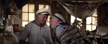 Movie still from “Popeye” (1980), directed by Robert Altman – Two men in sailor's hats are talking in a boat; Medium shot, Low angle