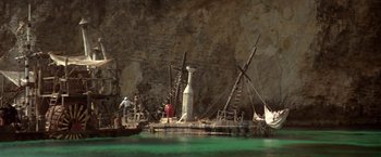 Movie still from “Popeye” (1980), directed by Robert Altman – A man standing on a dock next to a boat; Extreme Wide shot, High angle