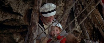 Movie still from “Popeye” (1980), directed by Robert Altman – An old man and a small child in a forest; Medium shot, High angle