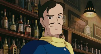 Movie still from “Porco Rosso” (1992), directed by Hayao Miyazaki – An animated man in a blue and yellow shirt; Close Up shot, Low angle