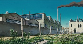 Movie still from “Porco Rosso” (1992), directed by Hayao Miyazaki – An industrial building with a fence around it and plants growing in the foreground; Extreme Wide shot, Low angle