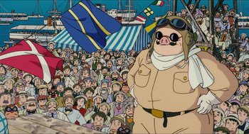 Movie still from “Porco Rosso” (1992), directed by Hayao Miyazaki – A crowd of people are gathered around a pig in a field; Medium shot, Low angle