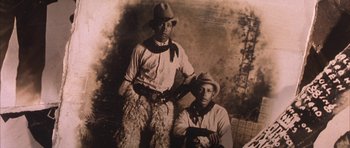 Movie still from “Posse” (1993), directed by Mario Van Peebles – A couple of men standing next to each other holding guns; Extreme Close Up shot, High angle