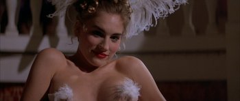 Movie still from “Posse” (1993), directed by Mario Van Peebles – A woman in a white dress with feathers on top of her head; Close Up shot, Over the shoulder angle
