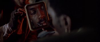 Movie still from “Posse” (1993), directed by Mario Van Peebles – A man looking at his reflection in a mirror; Extreme Close Up shot, Over the shoulder angle
