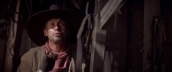 Movie still from “Posse” (1993), directed by Mario Van Peebles – A man wearing a cowboy hat in front of a wall; Close Up shot, Low angle