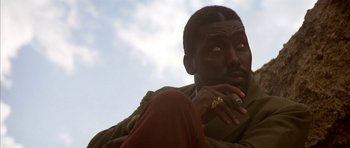 Movie still from “Posse” (1993), directed by Mario Van Peebles – A person with his hand on his chin; Close Up shot, Low angle