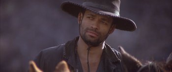 Movie still from “Posse” (1993), directed by Mario Van Peebles – A person wearing a hat; Close Up shot, Low angle