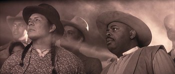 Movie still from “Posse” (1993), directed by Mario Van Peebles – Two men in cowboy hats are looking at something; Close Up shot, Low angle