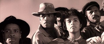 Movie still from “Posse” (1993), directed by Mario Van Peebles – A group of people standing next to each other wearing hats; Close Up shot, Low angle