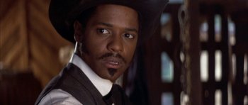 Movie still from “Posse” (1993), directed by Mario Van Peebles – A person wearing a cowboy hat; Close Up shot, Low angle
