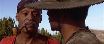 Movie still from “Posse” (1993), directed by Mario Van Peebles – Two men in cowboy hats looking into each other's eyes; Close Up shot, Over the shoulder angle