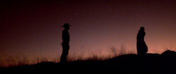 Movie still from “Posse” (1993), directed by Mario Van Peebles – A man standing on top of a grass covered hill; Wide shot, Low angle