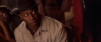 Movie still from “Posse” (1993), directed by Mario Van Peebles – A person wearing a hat and a jacket; Close Up shot, Over the shoulder angle