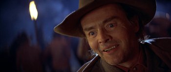 Movie still from “Posse” (1993), directed by Mario Van Peebles – A person wearing a hat and looking at the camera; Close Up shot, Over the shoulder angle