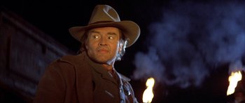 Movie still from “Posse” (1993), directed by Mario Van Peebles – A man wearing a hat and a jacket; Close Up shot, Low angle