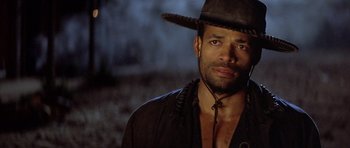 Movie still from “Posse” (1993), directed by Mario Van Peebles – A person wearing a cowboy hat; Close Up shot, Over the shoulder angle